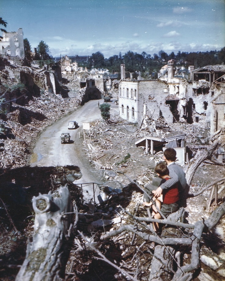 Deux enfants regardent les ruines de Saint-Lô du haut de la rue des Noyers, août 1944. 